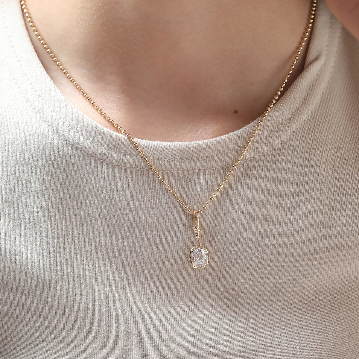 Long, old mine-cut, laboratory-grown diamond 2-carat bezel-set pendant necklace with cross chain.